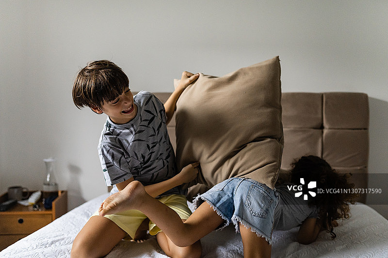 孩子们在床上嬉戏打闹图片素材