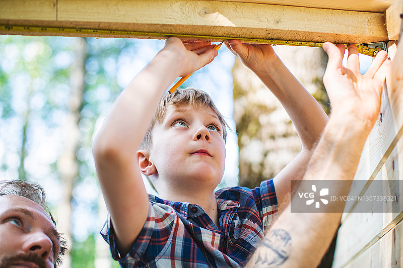 父子在后院建造树屋图片素材