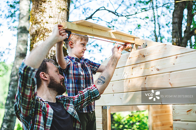 父子在后院建造树屋图片素材
