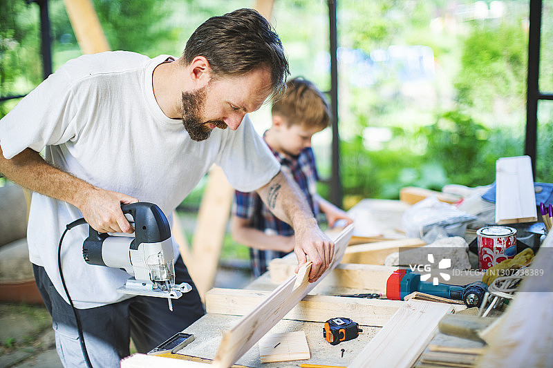 父子在后院建造树屋图片素材