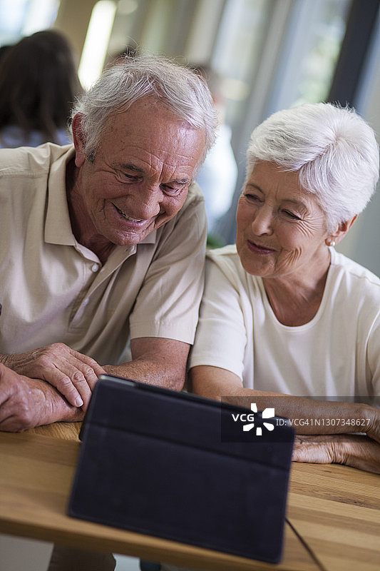 在咖啡店用平板电脑进行视频会议的老年夫妇图片素材