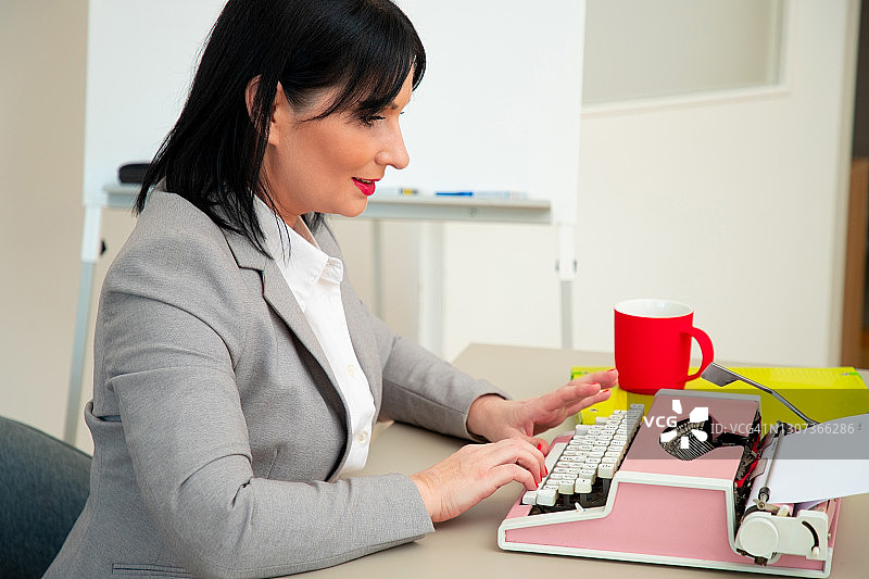 女人使用复古打字机打字图片素材