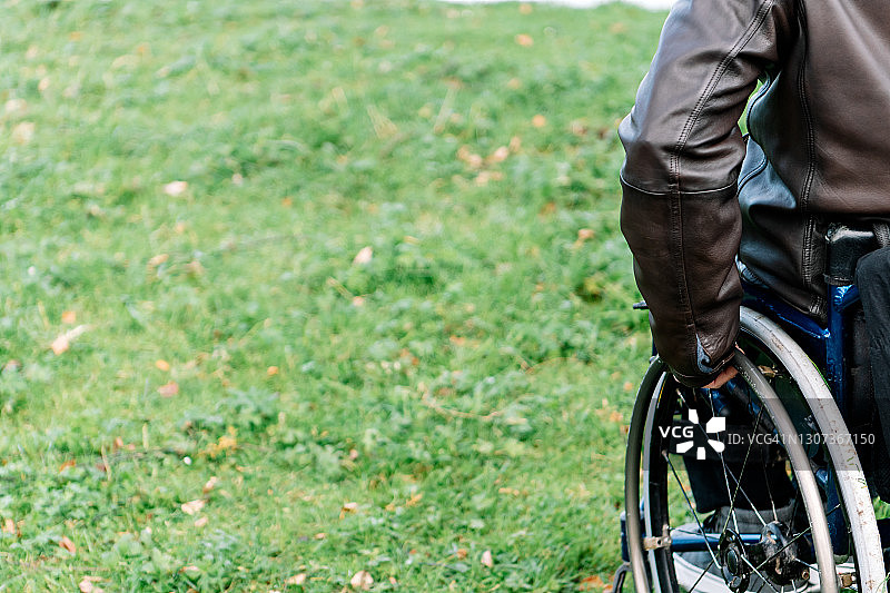 男人左手抓住轮椅左轮细节图片素材