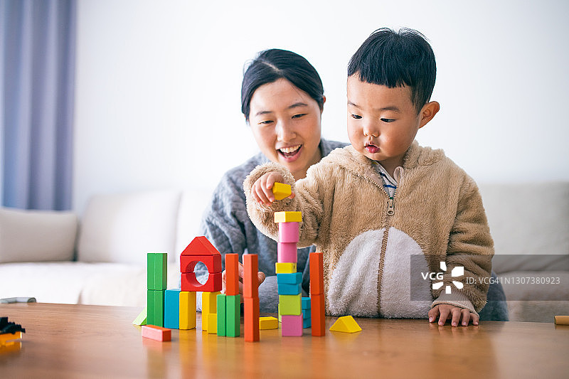 母亲和幼儿男孩玩积木图片素材