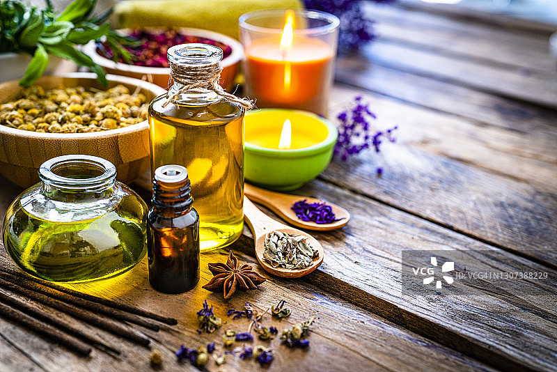 芳香疗法和替代医学：木桌上的按摩油和精油瓶，留白图片素材