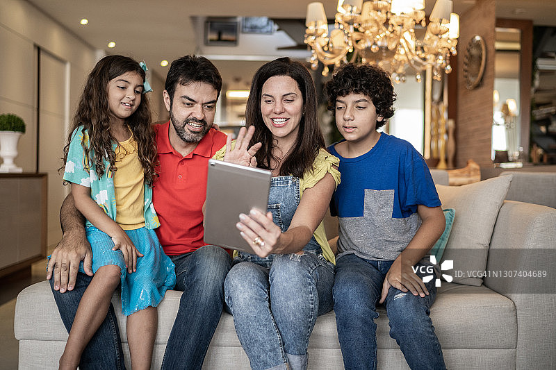 一家人在家中使用平板电脑进行视频通话图片素材