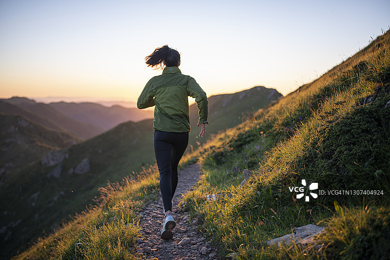 日落时分在山中奔跑的年轻女人图片素材