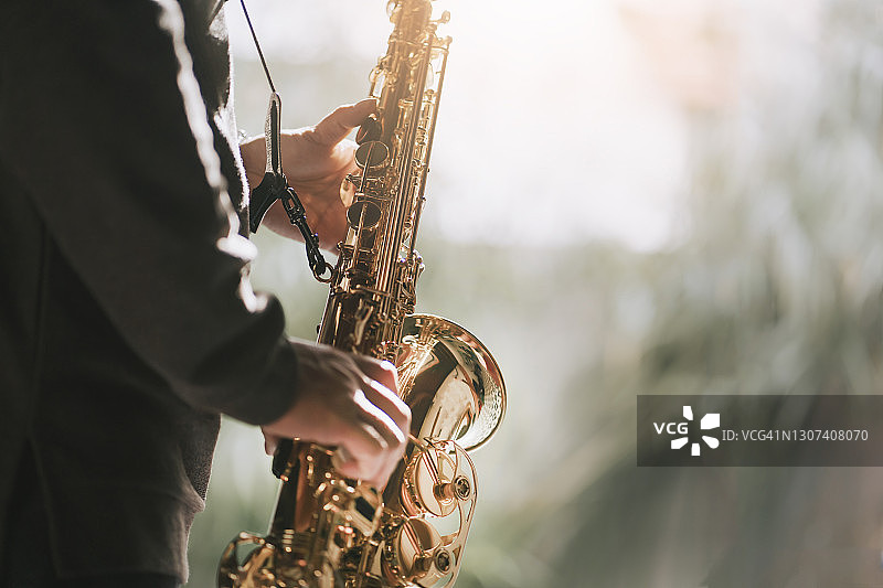 周末居家休闲练习萨克斯的中年亚洲男人图片素材