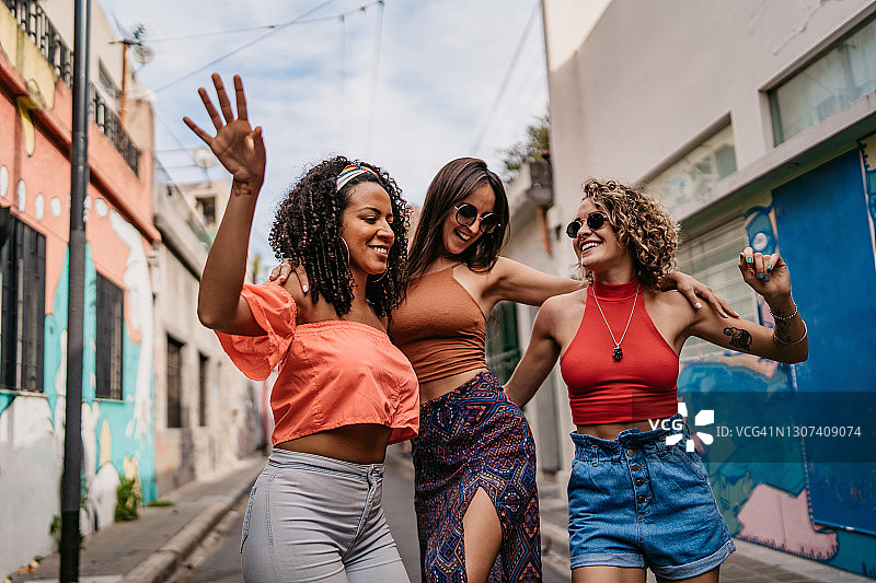 三个年轻女人走路和跳舞图片素材