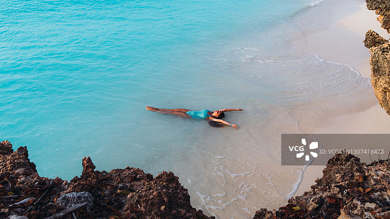 年轻女人在桑给巴尔岛明媚的日落时分在海边放松图片素材