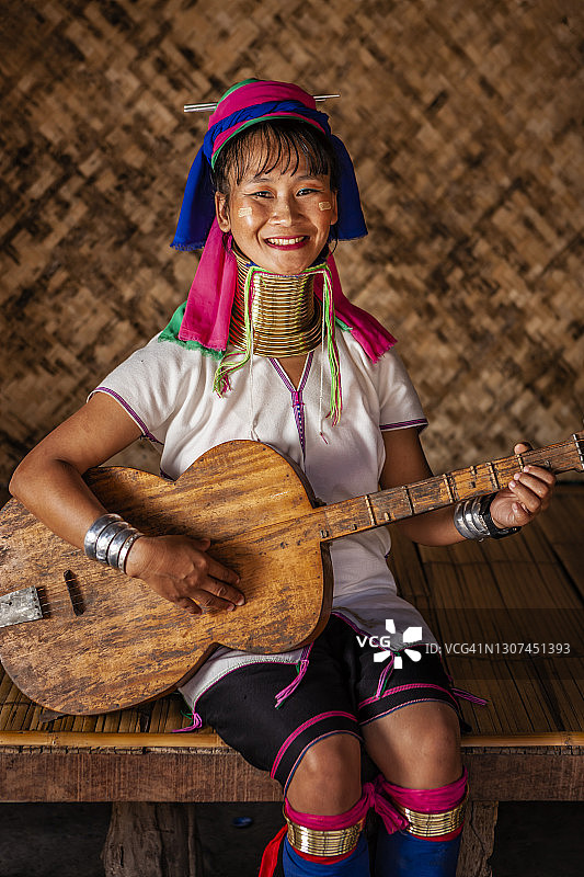 来自泰国北部克伦族长颈族的年轻女子在弹吉他图片素材