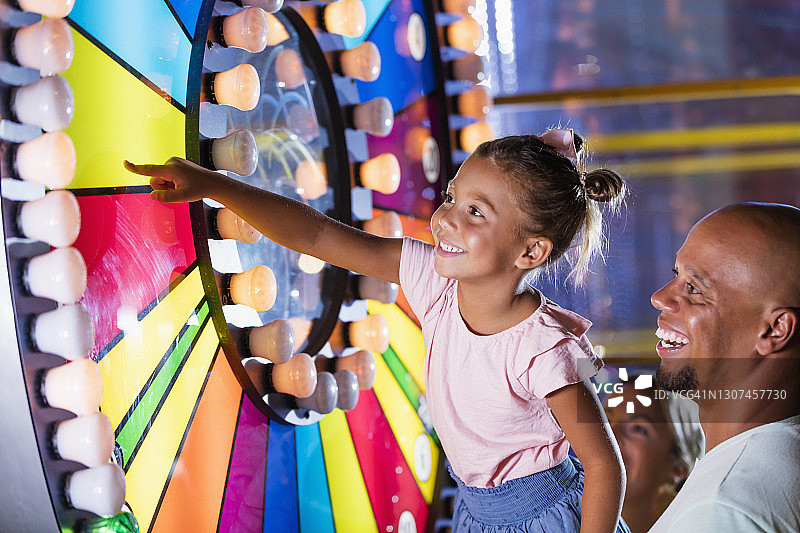 混血女孩和父亲在游乐厅图片素材