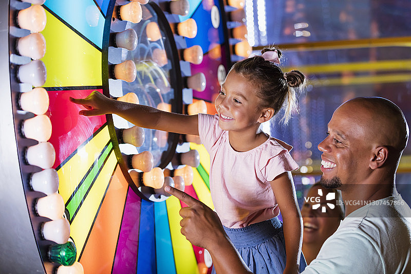 混血女孩和父亲在游乐厅图片素材