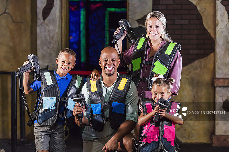 一个有两个孩子的跨种族家庭在玩激光标签图片素材