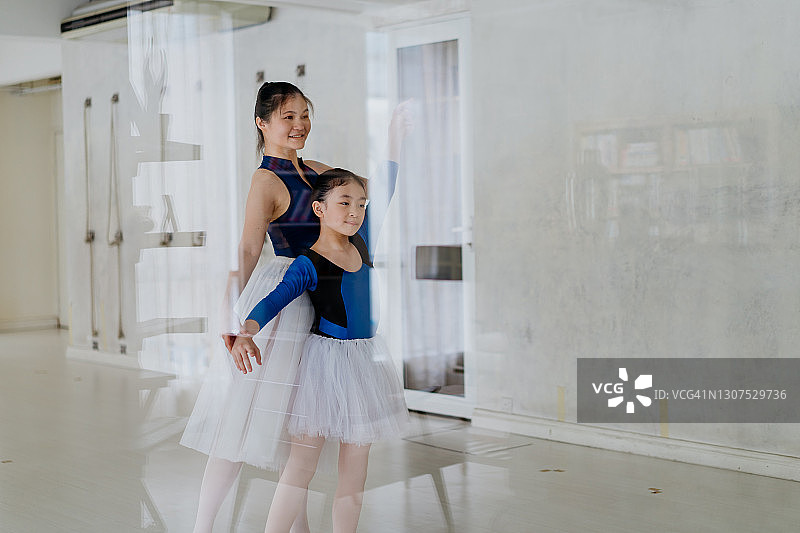 芭蕾舞老师在舞蹈工作室帮助小女孩图片素材