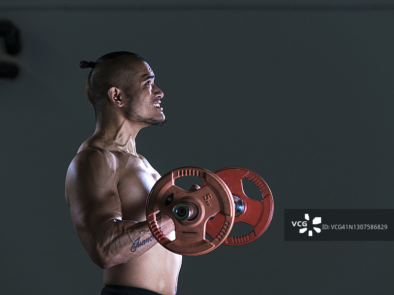 年轻健美的亚洲男子在健身房进行锻炼图片素材