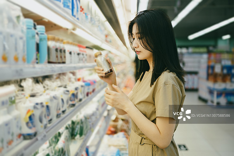 漂亮的亚洲女孩在超市购物图片素材