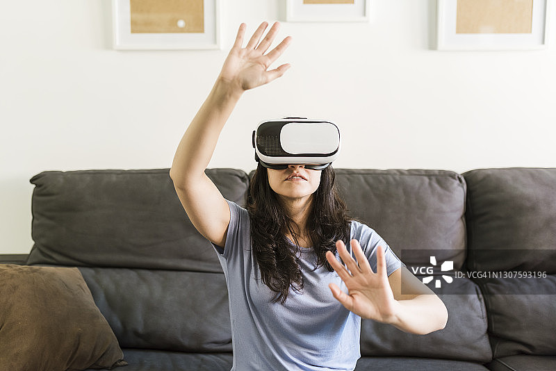 在家使用VR眼镜时做手势的女人图片素材
