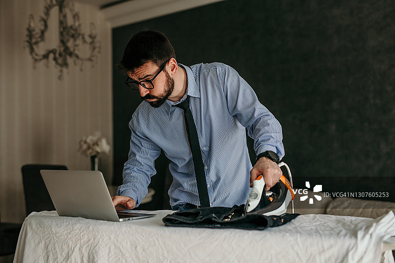 一边熨裤子一边发邮件图片素材