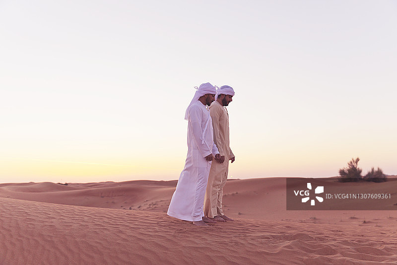 在阿拉伯沙丘上祈祷的阿拉伯男人图片素材