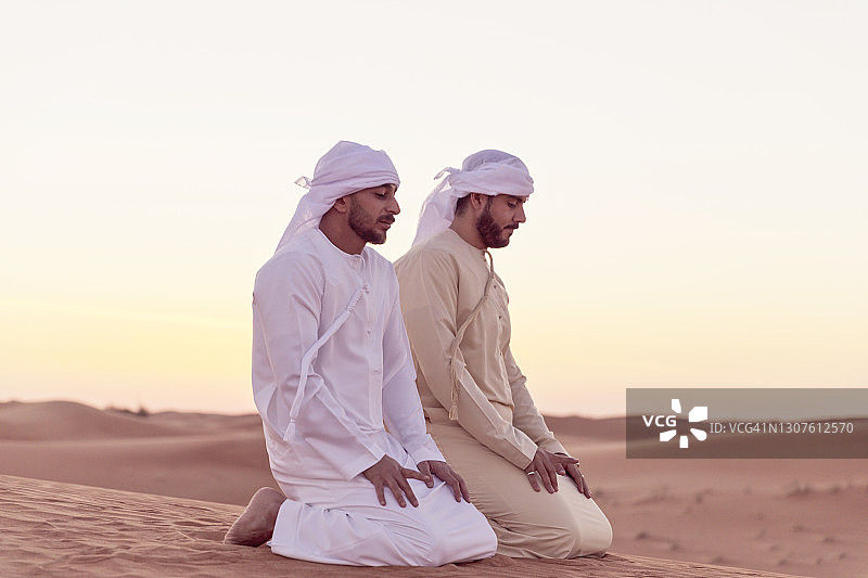 在阿拉伯沙丘上祈祷的阿拉伯男人图片素材