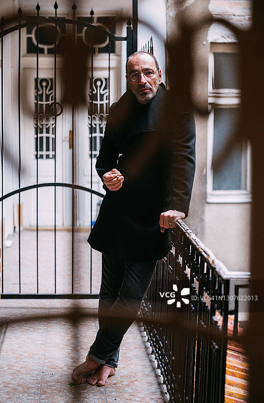 在阳台上吸烟的男人肖像图片素材