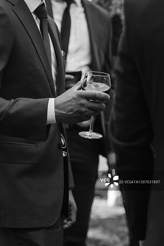 庆祝中的男人，身穿西装手持酒杯（黑白摄影）图片素材