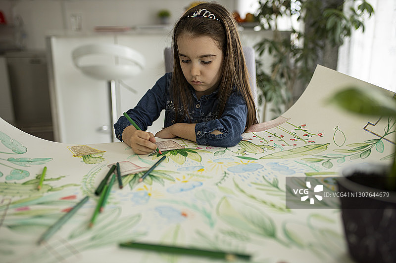 在餐厅绘画和着色的可爱小女孩图片素材