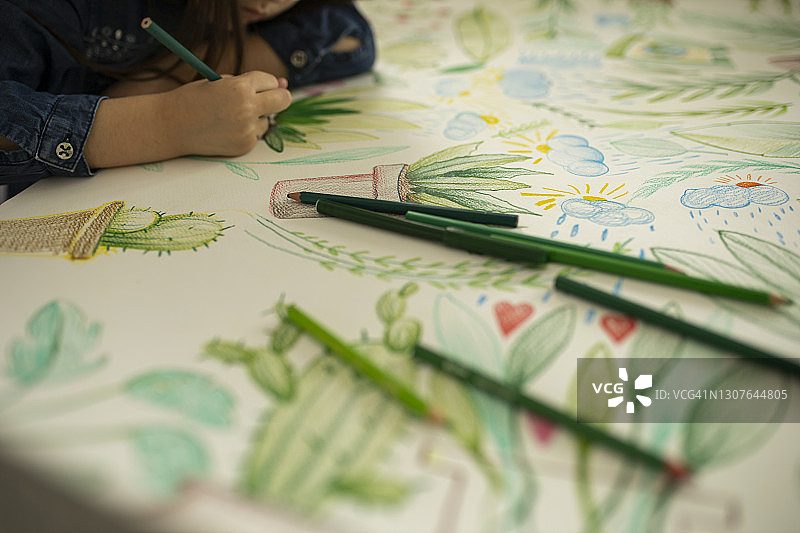 小女孩在纸上绘画和着色的俯视图图片素材