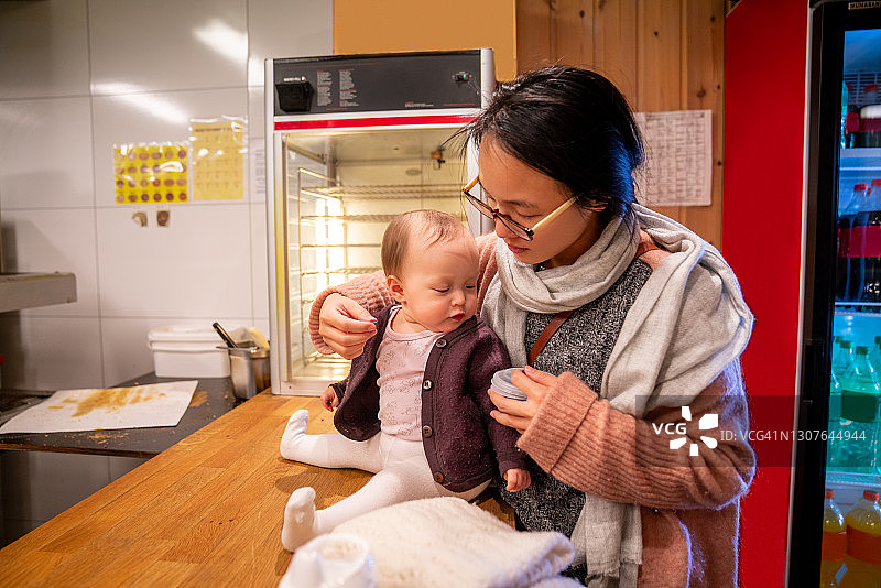 妈妈在商店柜台上抱着宝宝图片素材