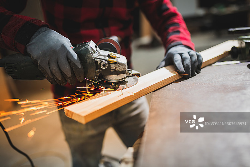 工业工人用角磨机切割木材和金属图片素材