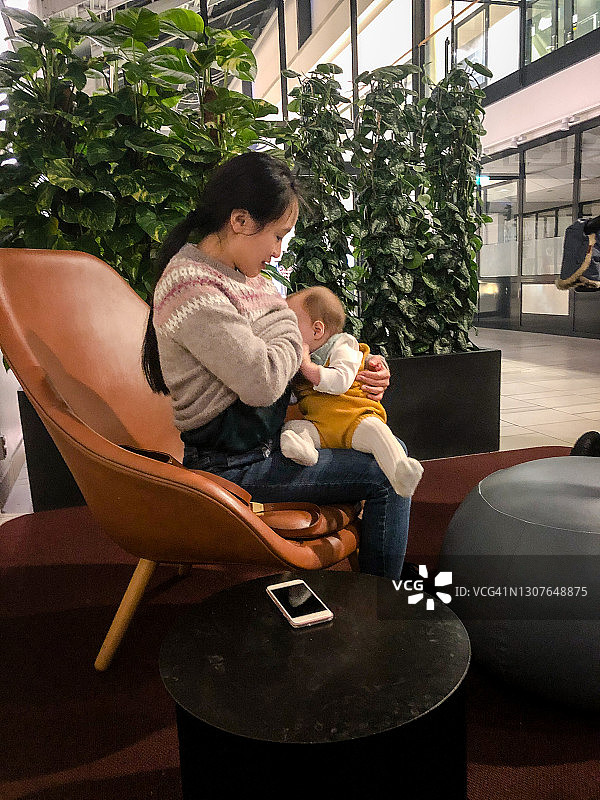 妈妈在哺乳区给女儿喂母乳图片素材