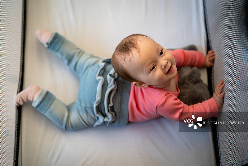 好奇的婴儿在婴儿床里向上看图片素材