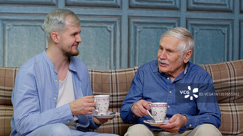 不同年龄段的男人：年长的父亲和成年的儿子或孙子在放松喝茶图片素材
