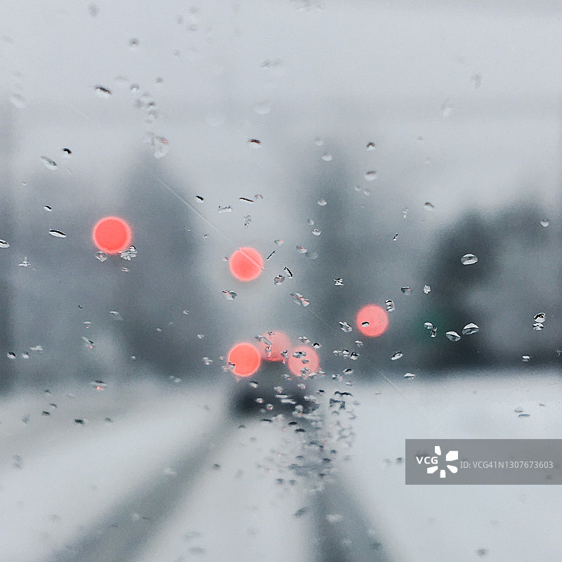 从潮湿的车窗看出去的雪路柔焦景色图片素材