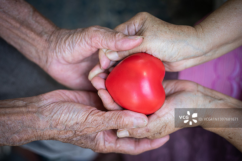拿着心形图案的老年人，心脏病概念，健康保险概念图片素材