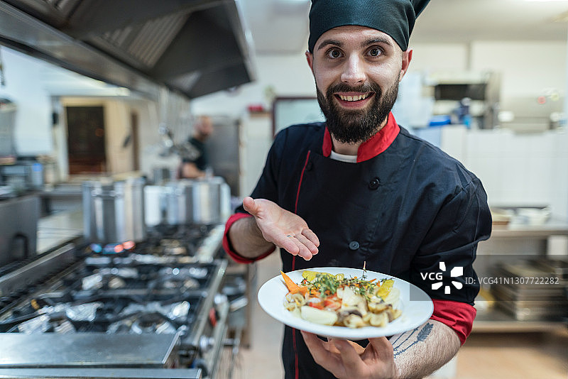 年轻男厨师在餐厅展示餐点图片素材
