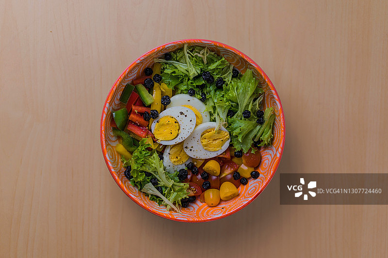 木桌上搭配精美碗具的健康鸡蛋沙拉图片素材
