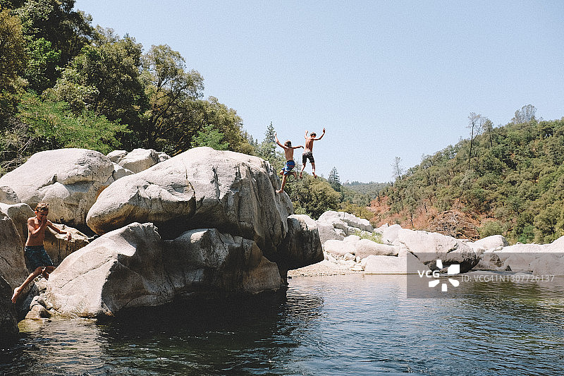 三个男孩同时跳入加利福尼亚州的游泳池图片素材