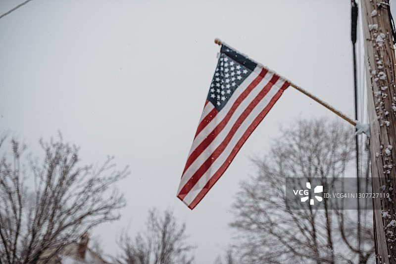 柔焦雪中旗杆上的美国国旗图片素材