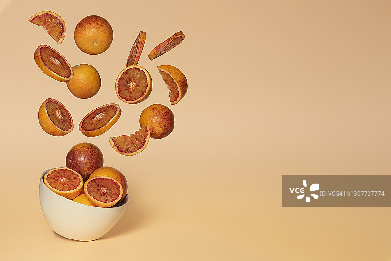 血橙爆炸，黄色背景，有留白。图片素材