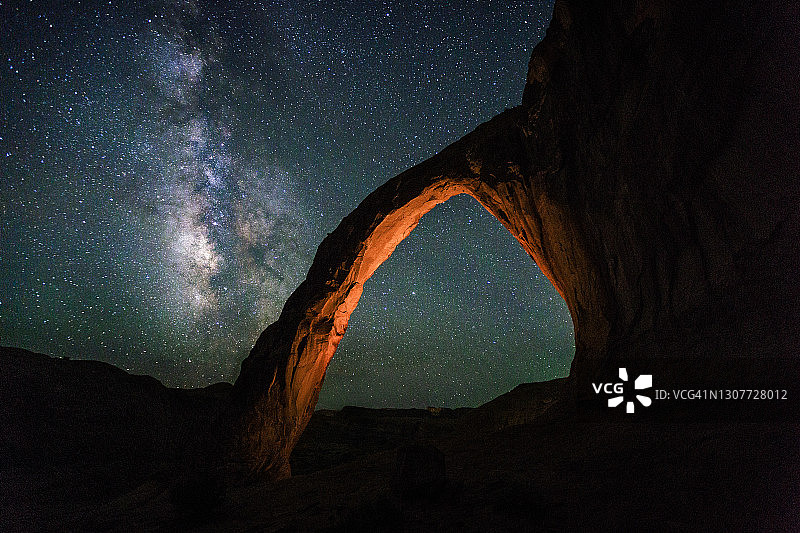 前景中带有温暖发光拱门的银河系观星图片素材