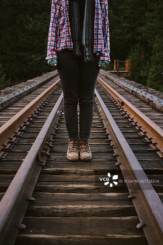 女人穿皮靴站在铁轨上图片素材