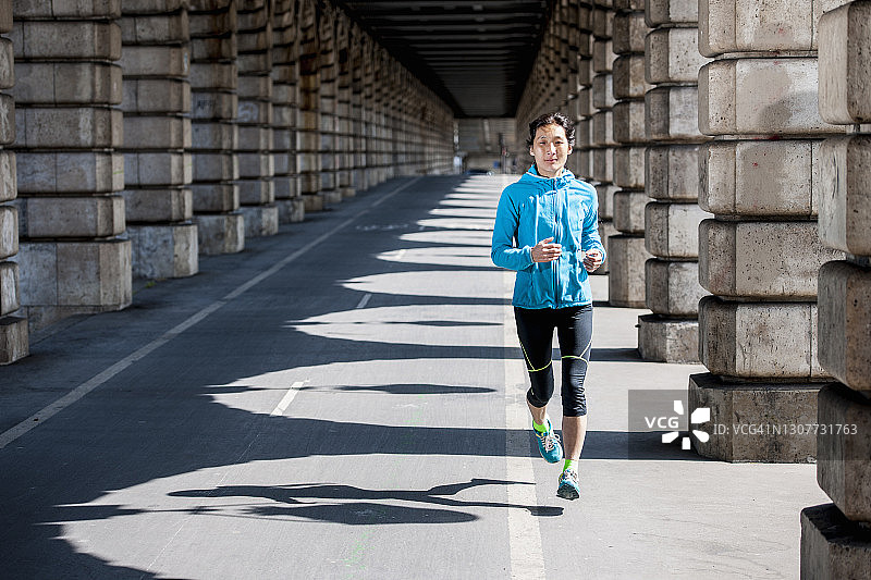 在巴黎地铁高架桥下跑步的女人图片素材