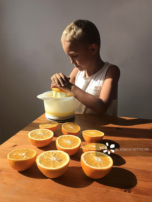 小男孩在厨房榨橙汁图片素材