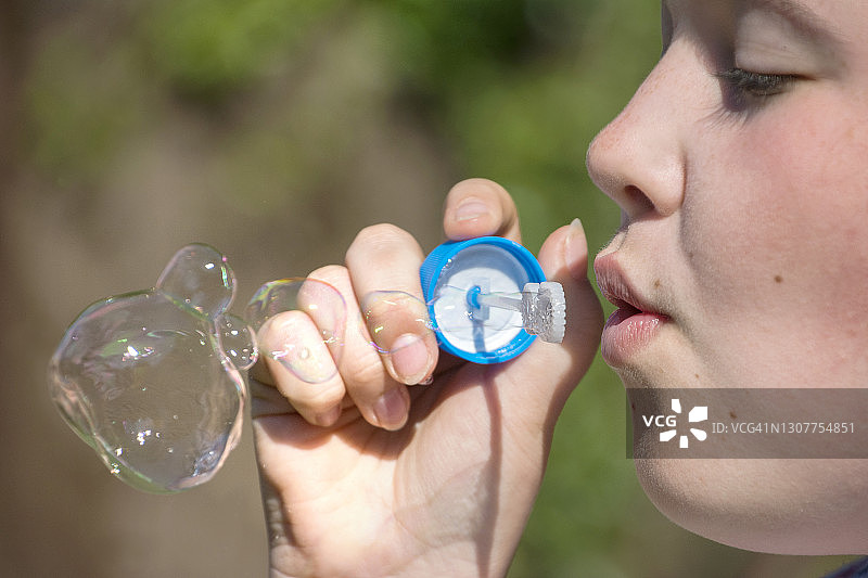 在户外吹泡泡的女孩图片素材