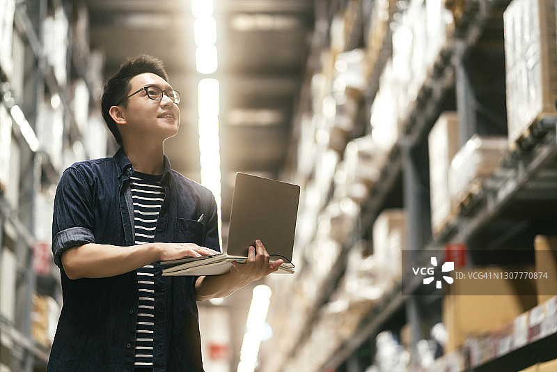 亚洲男企业主检查仓库库存的肖像图片素材