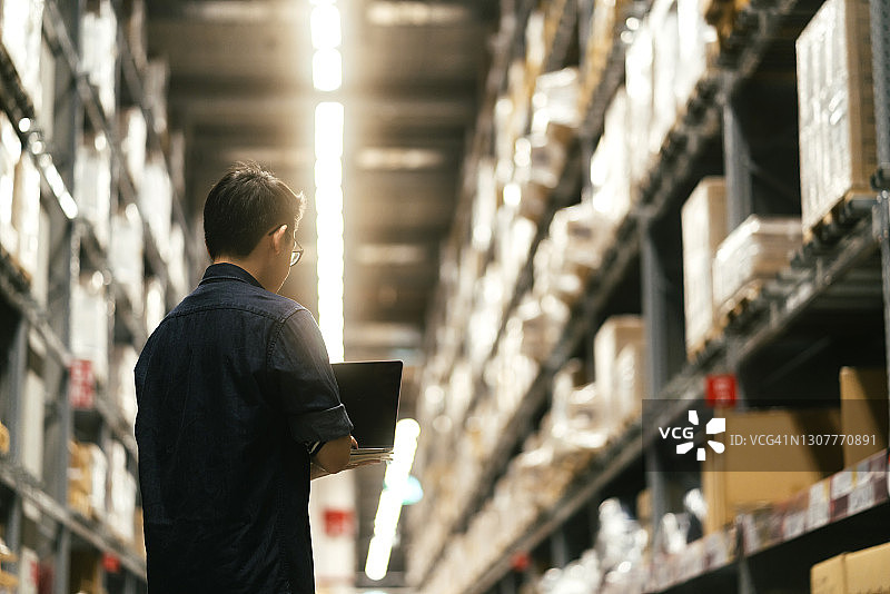 亚洲男企业主检查仓库库存的肖像图片素材