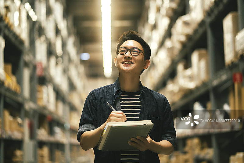 亚洲男企业主检查仓库库存的肖像图片素材