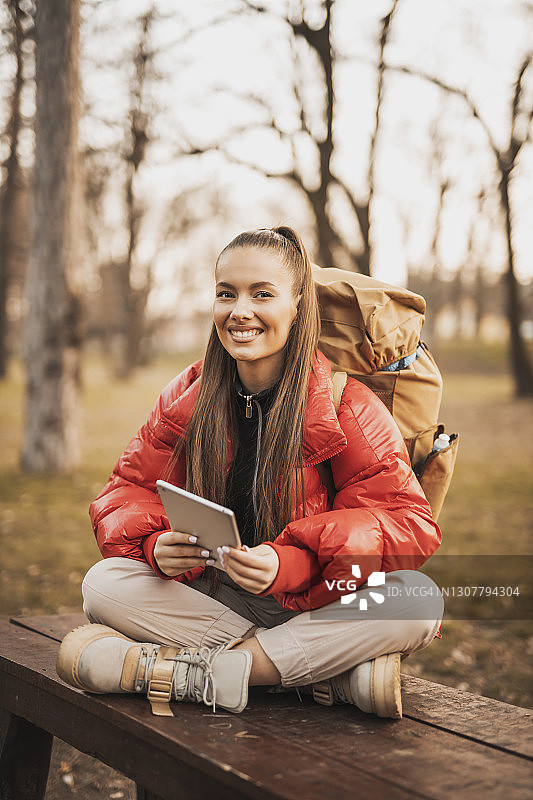 在山中徒步时使用平板电脑的年轻女人图片素材